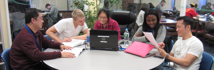 Five students sitting around a table studying